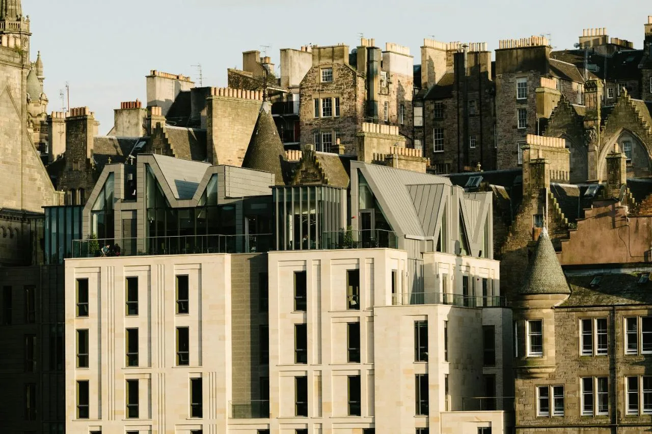 a white building in front of a group of buildings at Market Street hotel in Edinburgh
